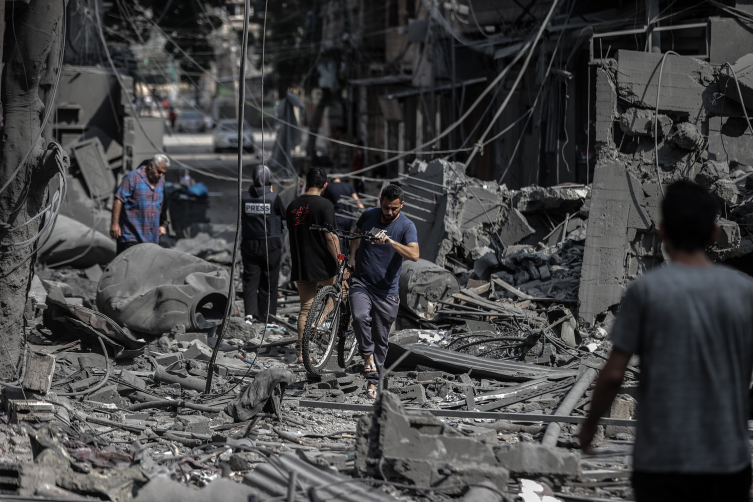 İsrail ordusunun yerle bir ettiği Gazze’de bombardıman sonrası geride kalanlar arasında dolaşan Filistinliler… Fotoğraf: AA